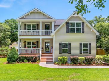 Charming two-story home with a inviting front porch and manicured lawn at 309 Pinopolis Park Dr, Moncks Corner, SC 29461
