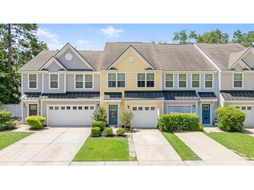 Charming townhomes featuring colorful facades, attached garages, and well-manicured landscaping at 412 Grand Palm Ln, Summerville, SC 29485