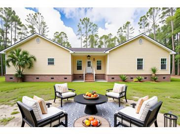 Charming yellow home with a well-maintained lawn and inviting outdoor seating area at 480 Longleaf Dr, Walterboro, SC 29488