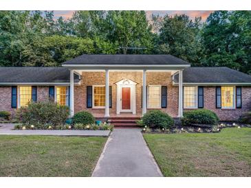 Charming brick home with a inviting red door, manicured landscaping, and classic shutters at 598 Maple Branch Rd, Reevesville, SC 29471