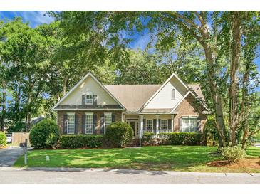 Charming home featuring a brick facade, well-manicured lawn, and mature trees, creating an inviting curb appeal at 652 Spinner Cir, Mount Pleasant, SC 29464