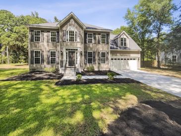 Charming two-story home with landscaped front yard, concrete driveway, and attached two-car garage at 702 Spark St, Mount Pleasant, SC 29464