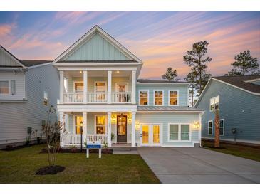 Stunning two-story home with a welcoming front porch and balcony, featuring light blue siding and white trim at 766 Maynard Ln, Summerville, SC 29486