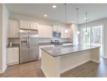 Modern kitchen with stainless steel appliances, granite countertops, and a large island at 9430 Sweep Dr, Summerville, SC 29485