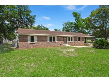 Charming brick ranch-style home featuring a well-manicured lawn and mature trees offering plenty of shade at 122 Lawrence Rd, Moncks Corner, SC 29461