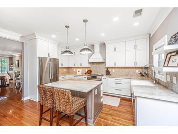 Bright eat-in kitchen boasts stainless appliances, an island, and ample white cabinetry at 136 Fair Sailing Rd, Mount Pleasant, SC 29466