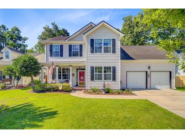 Charming two-story home featuring a well-manicured lawn, a two-car garage, and a lovely front garden at 180 Willowbend Ln, Summerville, SC 29485