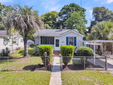 Charming single-story home with a well-manicured lawn, mature trees, and a quaint, gated front yard at 2215 Suffolk St, North Charleston, SC 29405