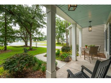 Inviting front porch with peaceful view of lake, hammock, and mature trees at 233 Camber Rd, Huger, SC 29450