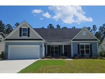 Charming one-story home with blue siding, a two-car garage, and a well-manicured front lawn at 265 Huguenot Trl, Huger, SC 29450