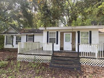 Exterior front view of a single-story home featuring white siding, and a small porch with lattice trim at 301 Haynesville Rd, Moncks Corner, SC 29461