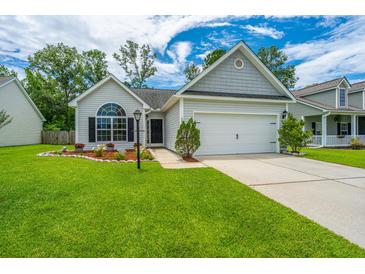 Charming single-story home boasts a well-manicured lawn, inviting curb appeal, and an attached two-car garage at 309 Hathaway Dr, Goose Creek, SC 29445