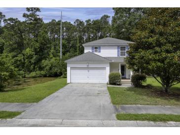 Charming two-story home with white siding, blue shutters, attached garage and mature landscaping at 340 Stefan Dr, Charleston, SC 29412