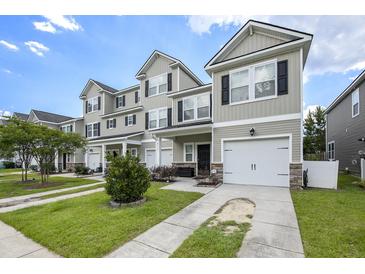 Well-manicured townhomes with attached garages, sidewalks, and landscaping, providing curb appeal at 4117 Rigsby Ln, Charleston, SC 29414