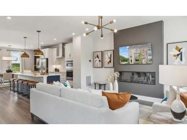 Bright living space featuring hardwood floors, modern fireplace, and open concept kitchen with bar stool seating at 552 Scholar Way, Summerville, SC 29486
