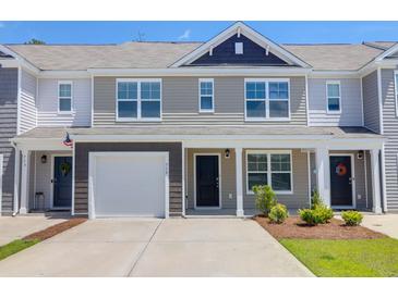 Inviting townhome exterior with a one car garage, gray tones, and well-manicured landscaping at 715 Hilchot Dr, Summerville, SC 29486