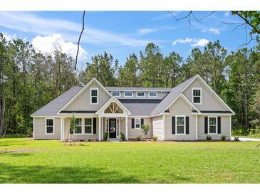 Charming single story home with a manicured lawn and inviting entrance at 0 Butterfly Ln, Awendaw, SC 29429