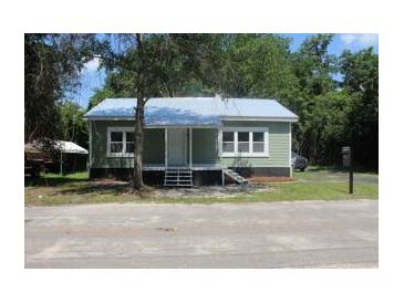 Charming cottage-style home featuring a light green exterior and a welcoming front porch at 103 Ann St, Saint George, SC 29477