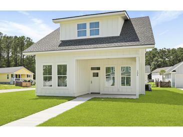 Charming white two-story home with covered porch and well-manicured lawn at 104 Brightwood Dr, Huger, SC 29450