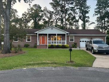 Charming brick home with a well-manicured lawn and an inviting front porch at 106 Labrador Ct, Summerville, SC 29485