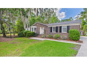 Charming brick home with a well-maintained lawn and mature trees draped in Spanish moss at 1225 Dennis Blvd, Moncks Corner, SC 29461
