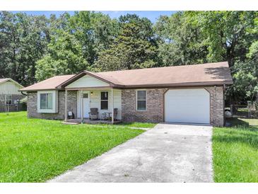 Charming single-story home with brick accents, a well-manicured lawn, and attached garage at 208 Janice St, Goose Creek, SC 29445