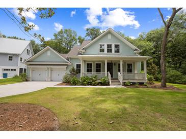 Charming two-story home featuring a welcoming front porch, complemented by a lush green lawn and manicured landscaping at 3226 Waverly Ln, Johns Island, SC 29455