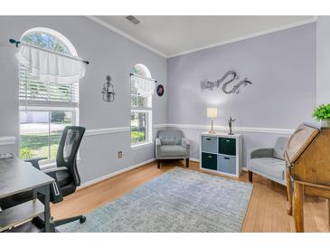 Inviting office space featuring hardwood floors, soothing gray walls, stylish decor, and abundant natural light from arched windows at 3257 Heathland Way, Mount Pleasant, SC 29466