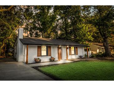 Charming brick home featuring a manicured lawn, wooden shutters, updated paint, and a new roof for great curb appeal at 1129 Dickson Ave, Hanahan, SC 29410