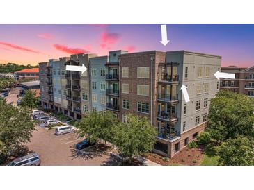 Stunning condominium complex with a mix of brick and siding, lush landscaping, and ample parking at 125 Pier View St # 408, Charleston, SC 29492
