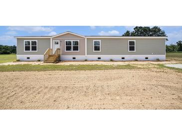 Charming single-story home featuring gray siding, white trim, and a welcoming front porch at 1332 Givhans Rd, Ridgeville, SC 29472