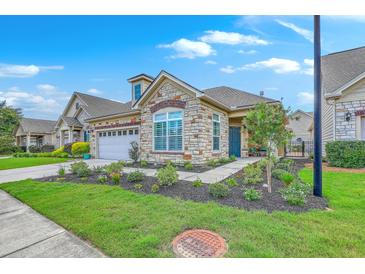 Charming single-story home with a stone facade, well-manicured lawn, and an attached two car garage at 269 Village Stone Cir, Summerville, SC 29483