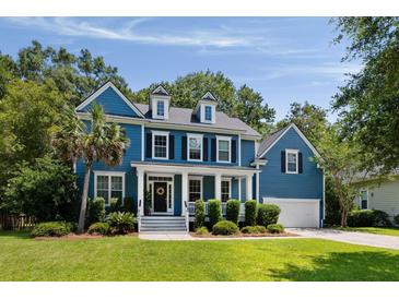 Charming blue two-story home featuring a well-manicured lawn, a columned porch and an attached two-car garage at 3574 Toomer Kiln Cir, Mount Pleasant, SC 29466