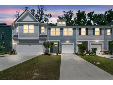 Charming townhome with gray siding, white garage doors, and well-maintained landscaping at sunset at 493 Trotters Ln, Moncks Corner, SC 29461