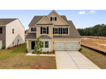 Charming two-story home featuring a two-car garage and manicured front lawn at 642 Red Monarch Way, Moncks Corner, SC 29461
