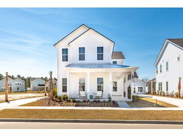 Charming two-story white home featuring a covered porch and beautifully landscaped front yard at 114 Battle Boat Blvd, Summerville, SC 29485