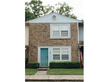 A cozy townhome showcases a charming brick exterior and a vibrant turquoise front door at 124 Brush Blvd, Goose Creek, SC 29445