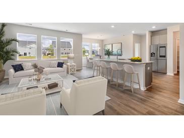 Bright, open-concept living room featuring a modern kitchen with a breakfast bar, stainless steel appliances, and hardwood floors at 515 Cropfield Dr, Summerville, SC 29485