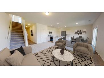 Open-concept living room featuring modern decor and seamless flow to the dining and kitchen areas at 5302 Bending Flats Way, Summerville, SC 29485