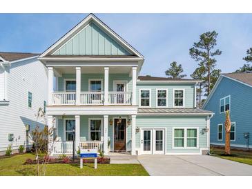 Charming two-story home featuring a welcoming porch, white columns, and a beautifully landscaped front yard at 705 Maynard Ln, Summerville, SC 29486