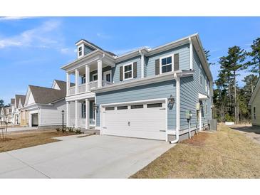 Stylish two-story home showcasing a blue exterior, white trim, a front porch, and an attached two-car garage at 764 Maynard Ln, Summerville, SC 29486