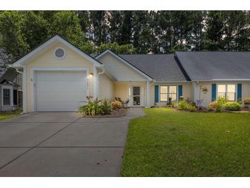 Charming single-story home with attached garage, well-manicured lawn, and welcoming front porch at 9091 Delancey Cir, North Charleston, SC 29406