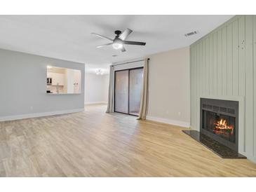 Bright living room with hardwood floors, ceiling fan and fireplace provides a comfortable living space at 1001 Waterwood Dr, Goose Creek, SC 29445