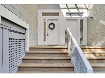 Inviting front door with a wreath and steps leading up to a covered porch area, perfect for guests at 1723 Live Oak Park, Seabrook Island, SC 29455