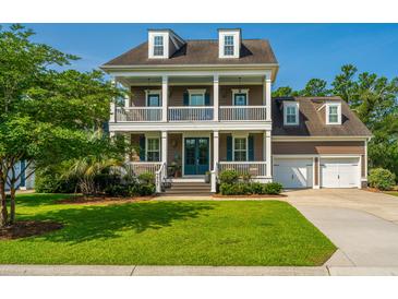 Charming two-story home with a welcoming front porch and manicured lawn on a sunny day at 2997 Sturbridge Rd, Mount Pleasant, SC 29466