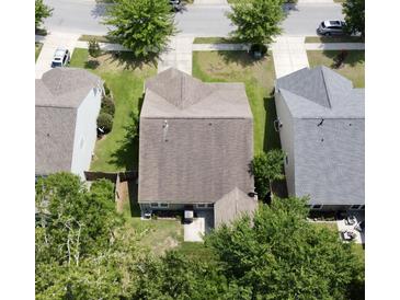 Aerial view of a home featuring a backyard with a small patio surrounded by green lawns and mature trees at 3198 Conservancy Ln, Charleston, SC 29414