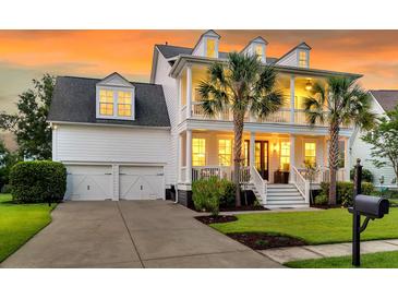 Charming two-story home with a welcoming porch, palm trees, and a two-car garage, all bathed in warm evening light at 3224 Hatchway Dr, Mount Pleasant, SC 29466