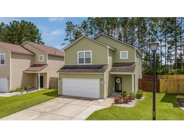 Two story home with attached garage, manicured lawn, and beautiful landscaping at 339 Iveson Rd, Summerville, SC 29486