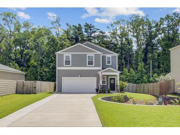 Charming two-story home featuring a well-manicured lawn, attached two car garage, and inviting front porch at 352 Matuskovic Dr, Charleston, SC 29414
