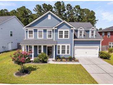Inviting two-story home featuring a manicured lawn and a two-car garage at 354 Beachgrass Ln, Summerville, SC 29486